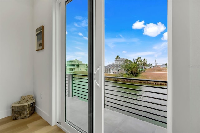 doorway with a water view and light wood-type flooring