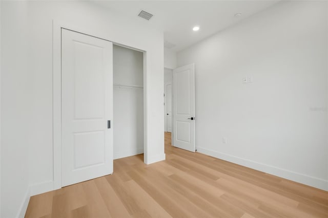 unfurnished bedroom with a closet and light hardwood / wood-style flooring