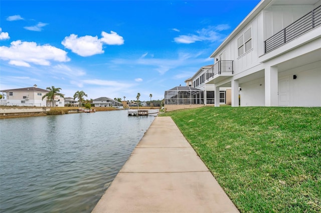 view of dock with a water view and a yard