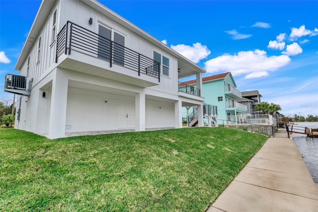 exterior space with cooling unit, a yard, and a balcony