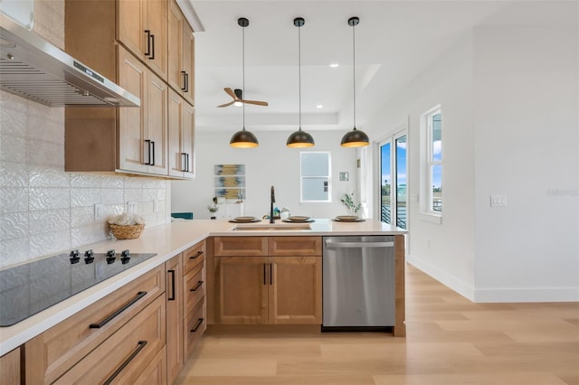 kitchen featuring pendant lighting, wall chimney range hood, sink, black electric stovetop, and stainless steel dishwasher