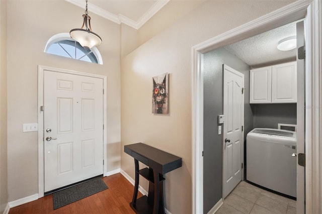 entrance foyer featuring crown molding, washer / clothes dryer, and light hardwood / wood-style flooring