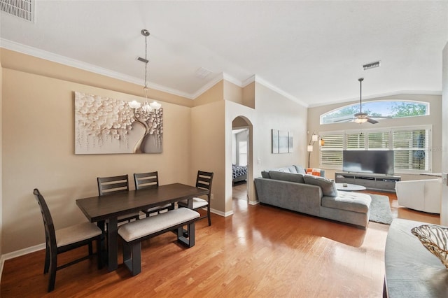 dining area with ceiling fan with notable chandelier, wood-type flooring, crown molding, and vaulted ceiling