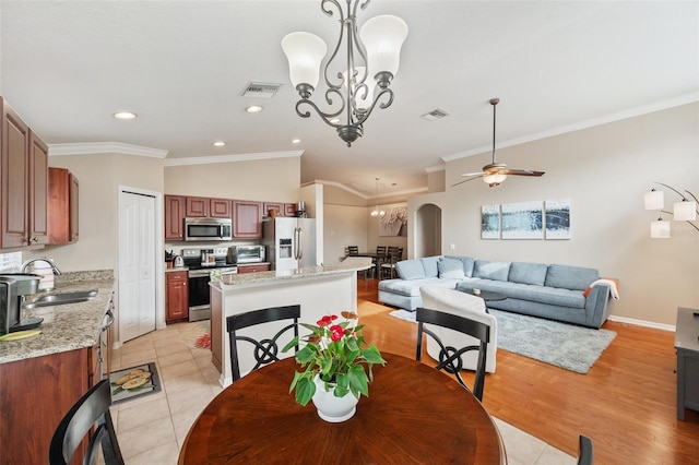 tiled dining room with ceiling fan with notable chandelier, sink, and ornamental molding