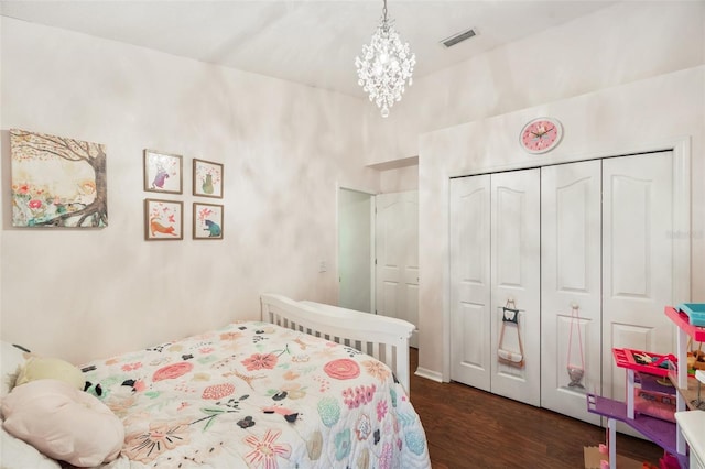 bedroom featuring a closet, a notable chandelier, and dark hardwood / wood-style flooring