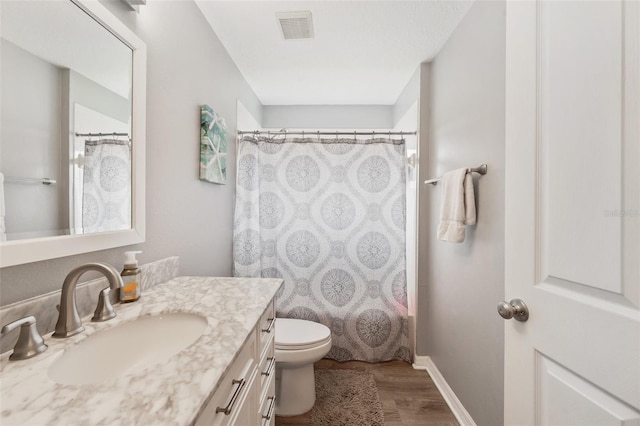 full bathroom with shower / bath combo with shower curtain, hardwood / wood-style flooring, toilet, and vanity