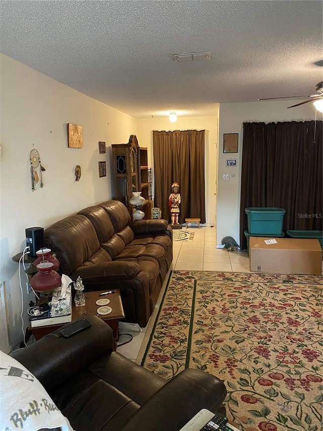 tiled living room featuring a textured ceiling and ceiling fan