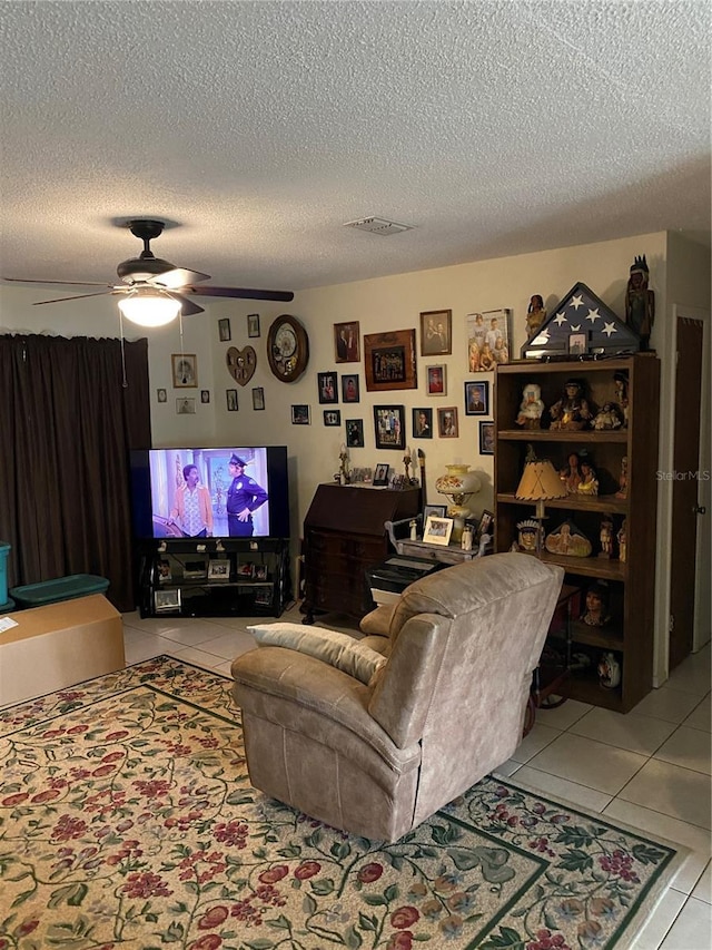 tiled living room featuring a textured ceiling and ceiling fan