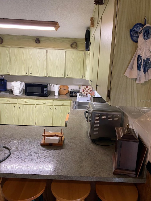 kitchen with light brown cabinets and a textured ceiling