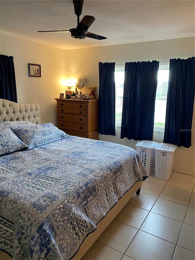 tiled bedroom with a textured ceiling and ceiling fan