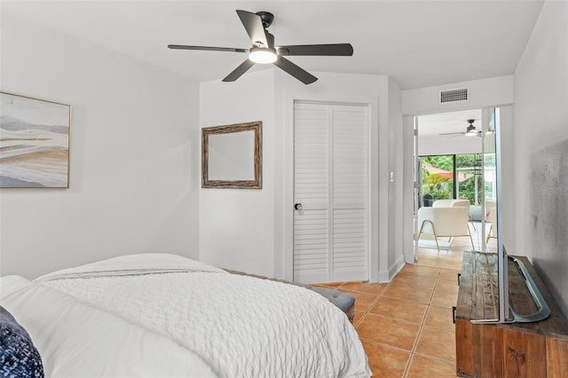 tiled bedroom with ceiling fan and a closet