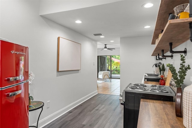 kitchen featuring dark wood-type flooring, sink, refrigerator, ceiling fan, and electric range