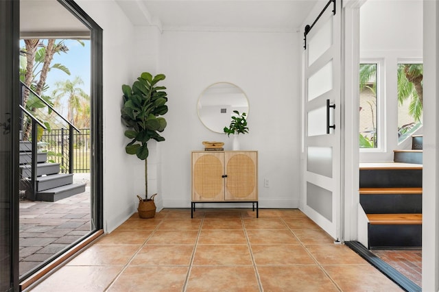 tiled foyer entrance with a barn door and a wealth of natural light