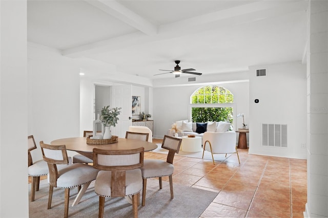 tiled dining area with ceiling fan and beamed ceiling