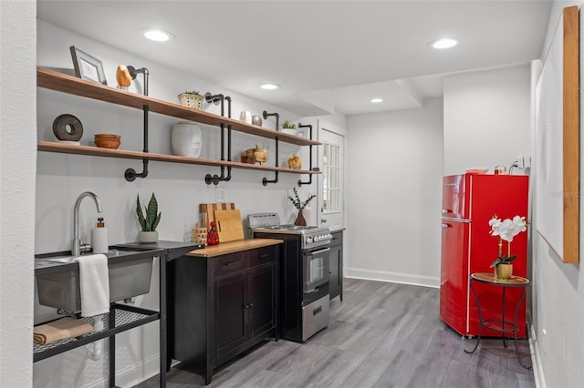 kitchen featuring light hardwood / wood-style floors, fridge, and stainless steel range oven