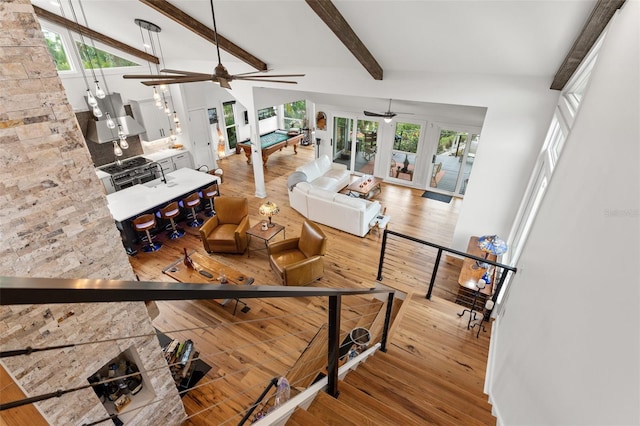 living room featuring wood-type flooring, billiards, and vaulted ceiling with beams