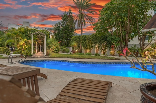 pool at dusk featuring a patio area