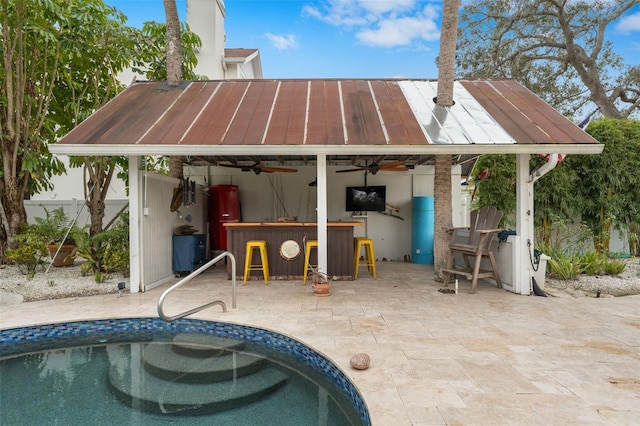 exterior space featuring ceiling fan, a patio area, and exterior bar