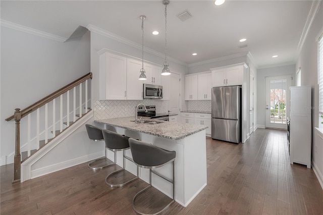 kitchen featuring white cabinetry, kitchen peninsula, decorative backsplash, hanging light fixtures, and appliances with stainless steel finishes