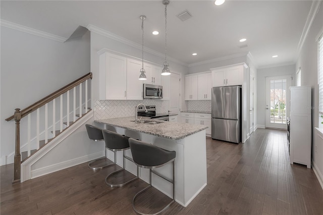 kitchen featuring white cabinetry, kitchen peninsula, backsplash, pendant lighting, and appliances with stainless steel finishes