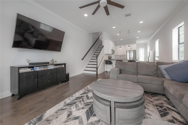 living room featuring ceiling fan, dark hardwood / wood-style flooring, and crown molding