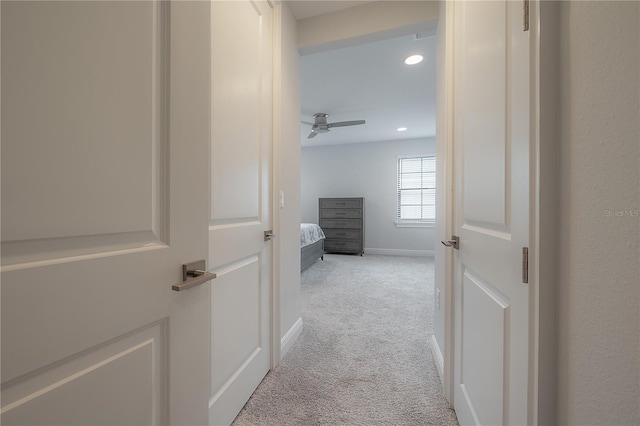 hallway featuring light colored carpet