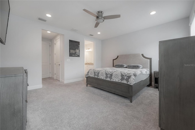 bedroom with ceiling fan, connected bathroom, and light carpet