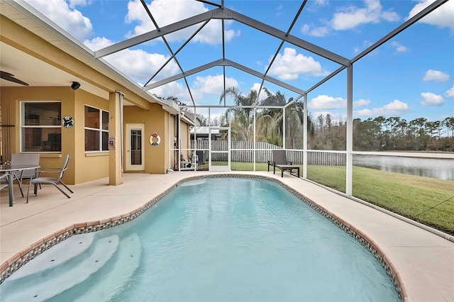 view of pool featuring a yard, a patio area, glass enclosure, and a water view