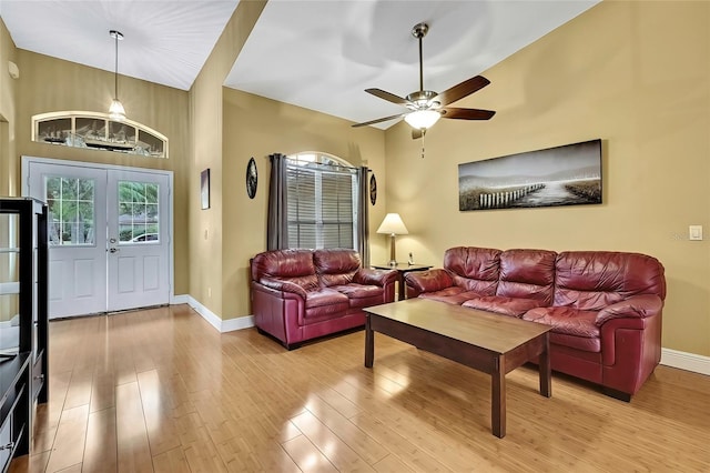 living room featuring french doors, light wood-type flooring, and ceiling fan