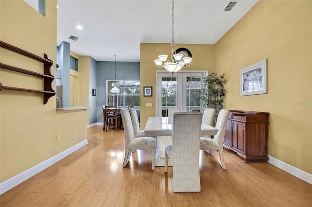 dining area with a notable chandelier and light hardwood / wood-style floors