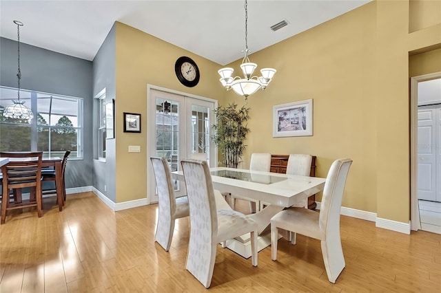 dining space with light wood-type flooring and a notable chandelier