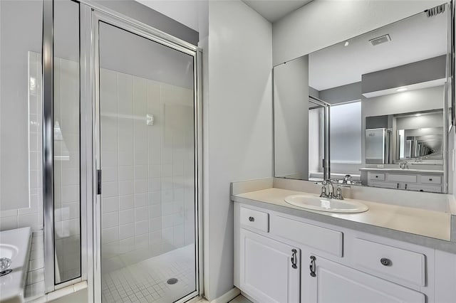 bathroom featuring a shower with shower door and vanity