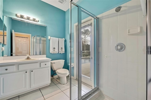 bathroom with toilet, tile patterned flooring, a shower with shower door, and vanity