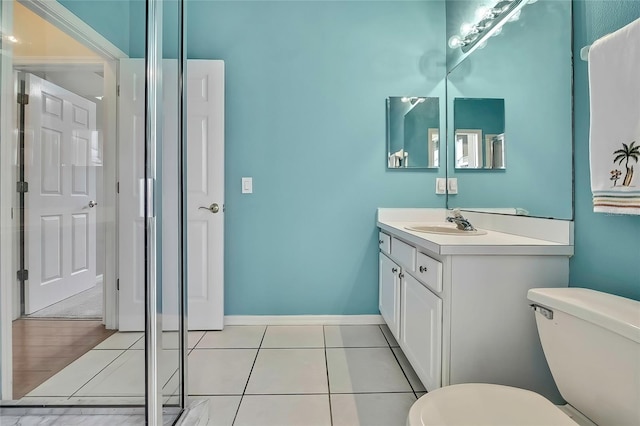 bathroom with toilet, tile patterned floors, and vanity