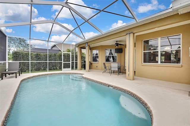 view of pool featuring ceiling fan, glass enclosure, and a patio area