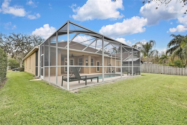 back of house with a yard, ceiling fan, a lanai, a fenced in pool, and a patio area