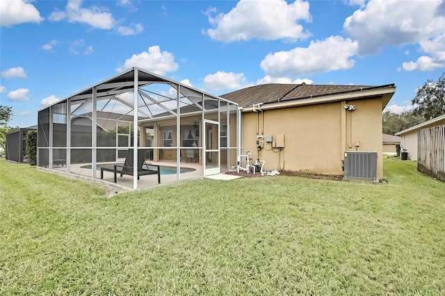 rear view of house featuring a lawn, cooling unit, a patio area, and glass enclosure