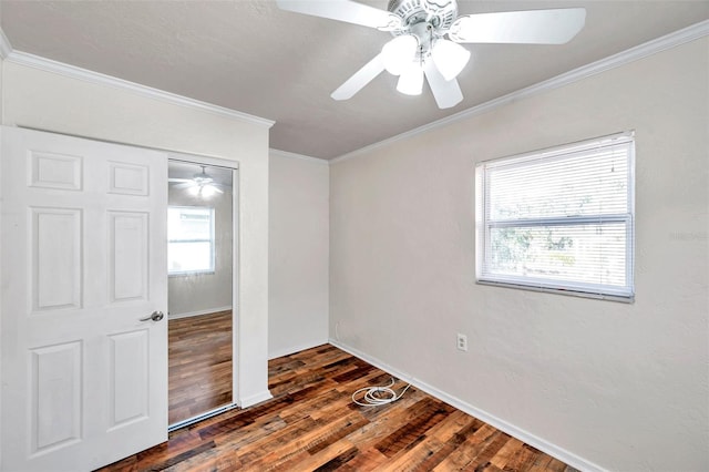 empty room with ceiling fan, dark hardwood / wood-style flooring, and ornamental molding