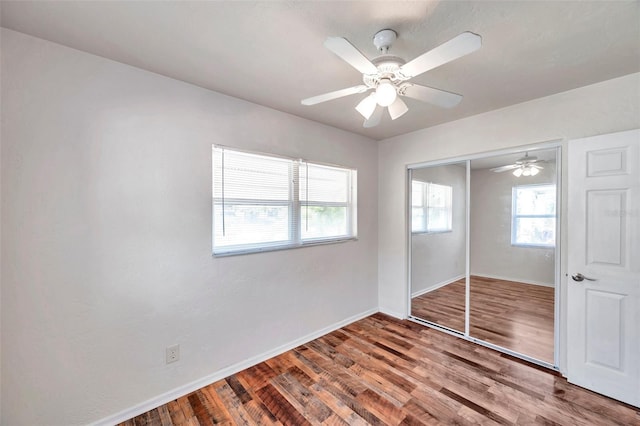 unfurnished bedroom featuring ceiling fan, a closet, and wood-type flooring