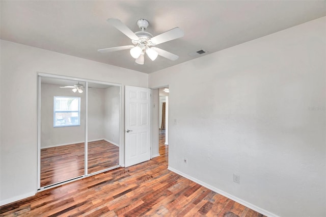 unfurnished bedroom featuring ceiling fan, a closet, and hardwood / wood-style floors