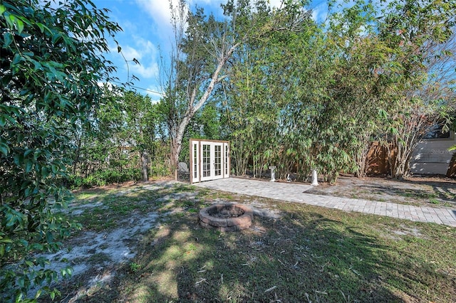 view of yard with french doors and an outdoor fire pit