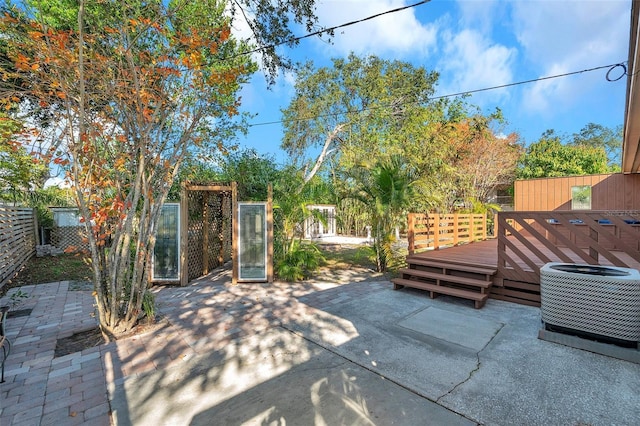 view of patio / terrace with central AC unit and a wooden deck