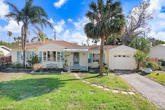 ranch-style house featuring a garage and a front lawn