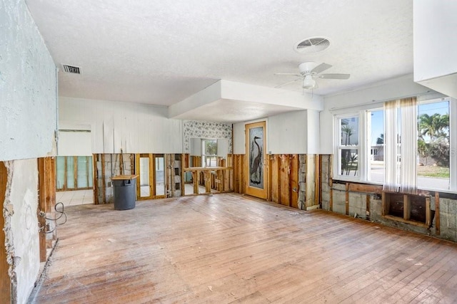 misc room with a textured ceiling, ceiling fan, and light hardwood / wood-style flooring