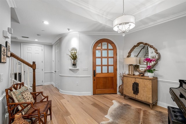 foyer with wood-type flooring and ornamental molding