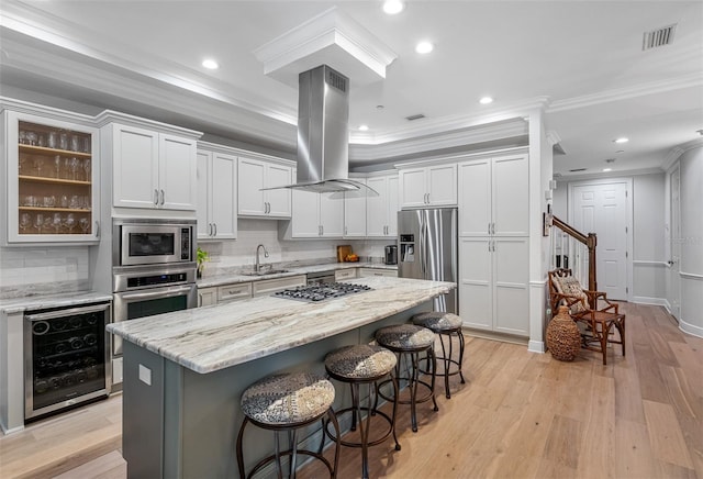 kitchen with sink, white cabinetry, island exhaust hood, wine cooler, and appliances with stainless steel finishes