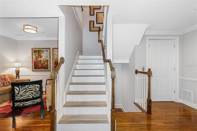 staircase featuring hardwood / wood-style floors and crown molding