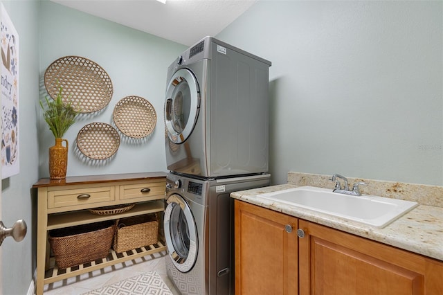 laundry area featuring sink, cabinets, stacked washer / dryer, and light tile patterned floors