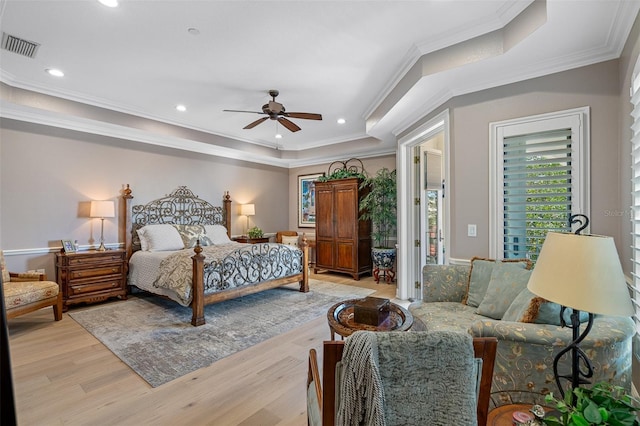 bedroom featuring access to exterior, ceiling fan, light wood-type flooring, a tray ceiling, and crown molding