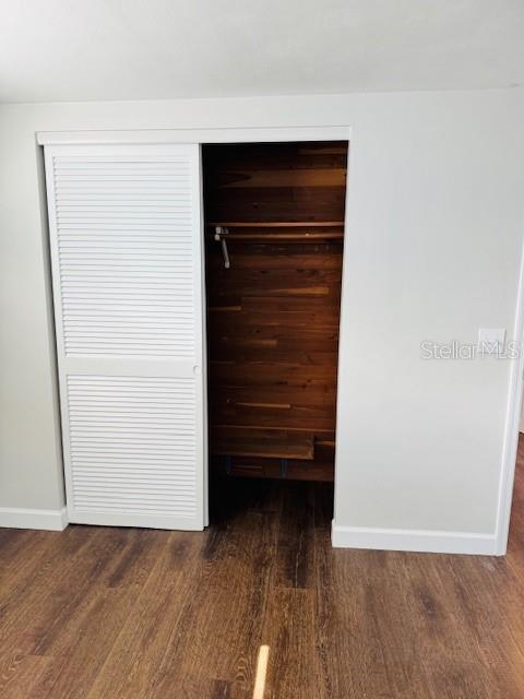 unfurnished bedroom featuring a closet and dark hardwood / wood-style flooring